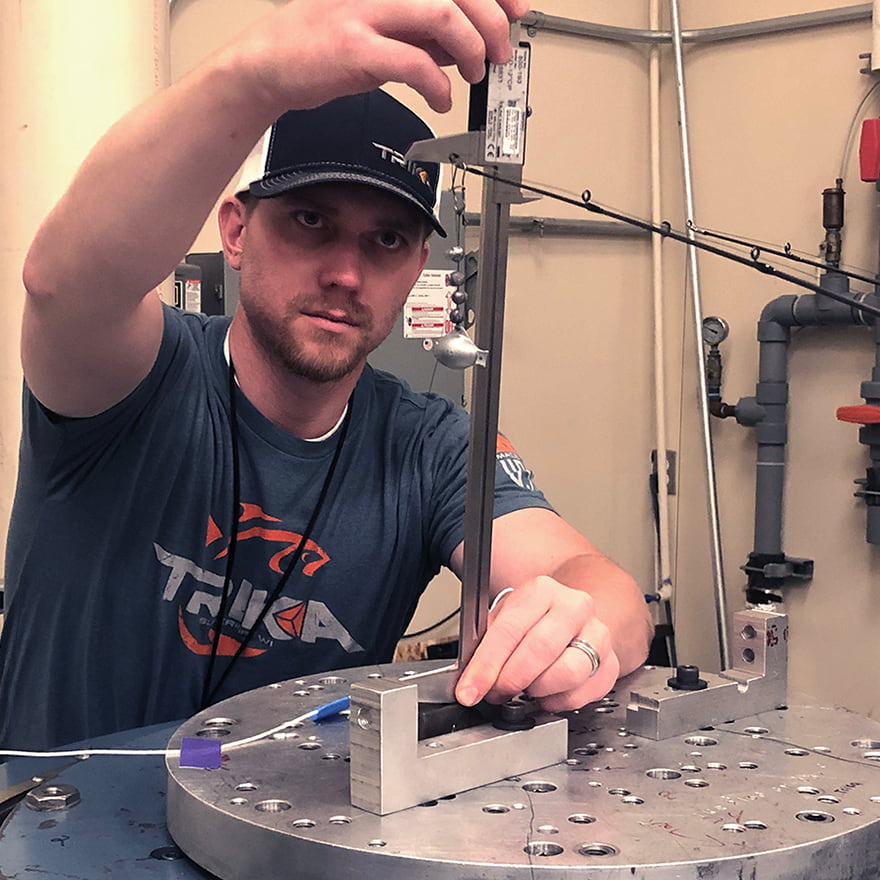 An engineer testing how far the Trika fishing rods can bend and how durable the Kigan guides are