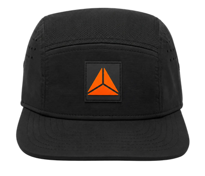 A black five-panel camp cap with a unstructured brim, featuring a square black patch on the front with Trika logo.